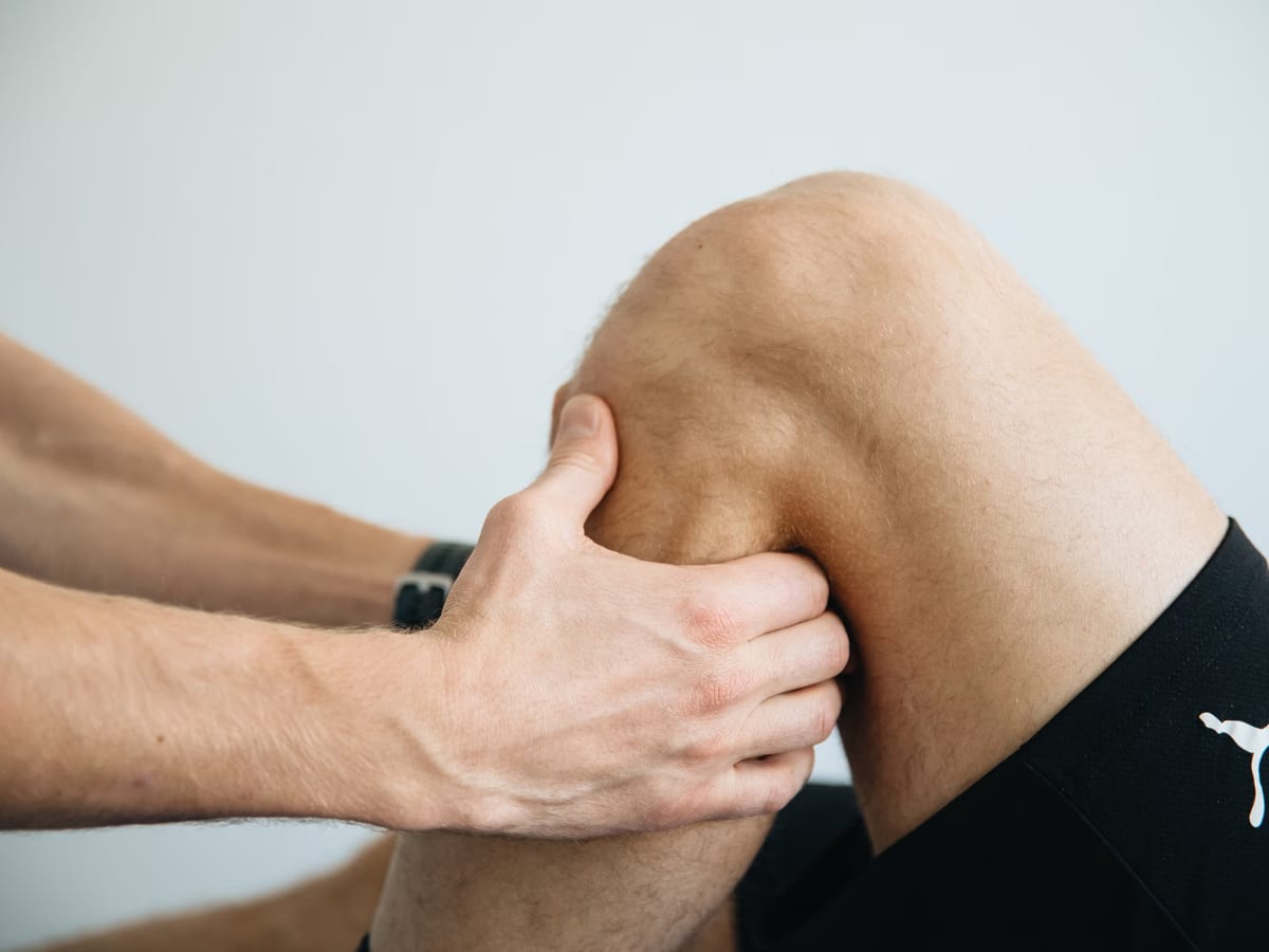 A physiotherapist guiding an athlete through a controlled rehabilitation progression