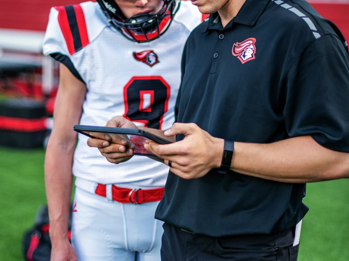 An analyst comparing squad performance data across two screens in a club office